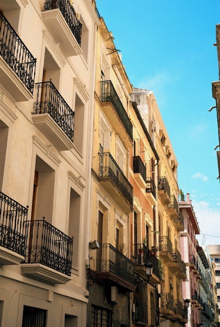 Spanish urban street with white facade and wrought-iron balconies