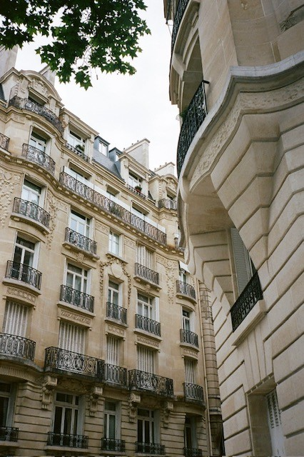 Ornate French apartment facades with wrought-iron balconies